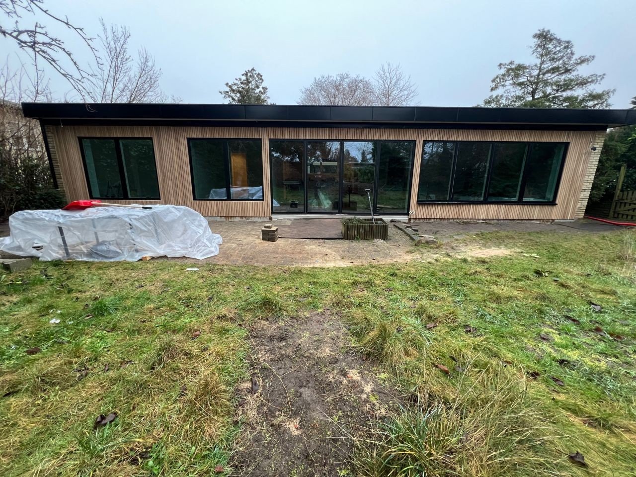 Parcelhus før renovering med egetræslister og sort aluminium